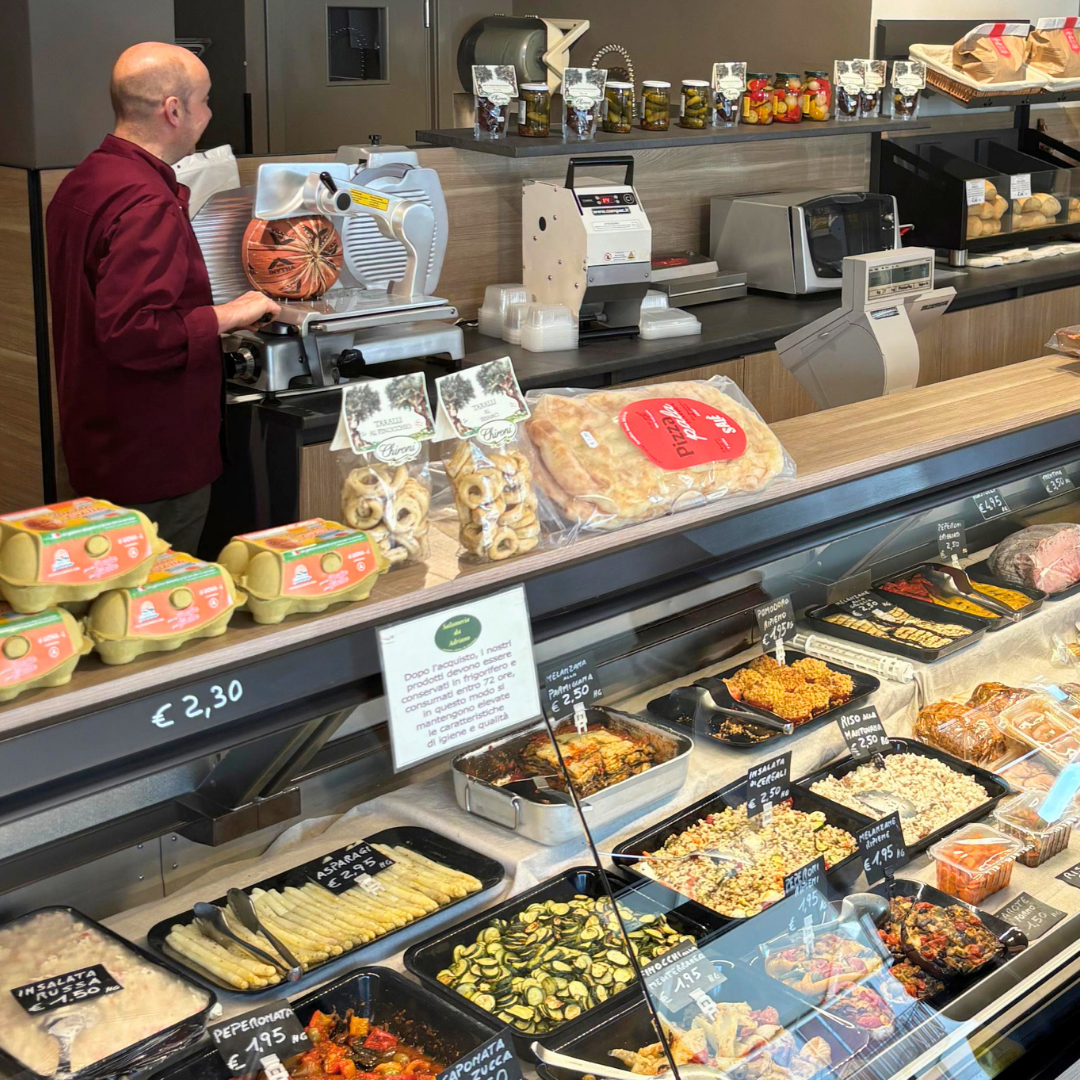 Affettatrice e banco gastronomia con piatti pronti e specialità