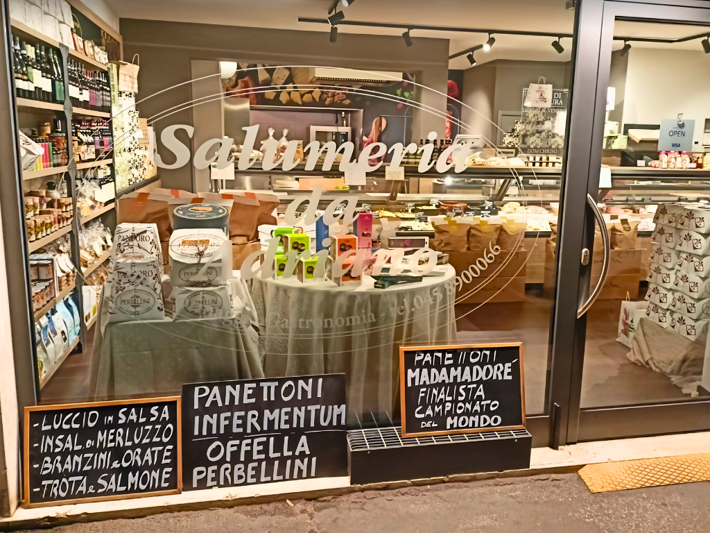 Vetrina della Salumeria da Adriano con panettoni Infermentum e Madamadoré